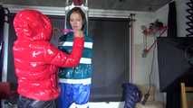 SEXY RONJA wearing shiny nylon downwear being tied and hooded with tapes from Stella on a rack (Video)