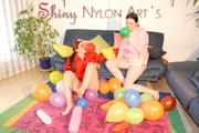 Jill and a friend of her wearing shiny nylon shorts and rain jacket playing with baloons (Pics)