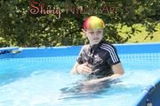 Mara sunbathing and swimming in the pool wearing a supersexy black adidas shiny nylon rainwear (Pics)