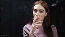 Redhead lady is smoking two cigarettes in the studio