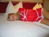 Beautiful archive girl tied and gagged on a bed wearing shiny shorts (Pics)