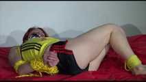 Sonja tied and gagged with ropes and cloth gag on a bed wearing a sexy black shiny nylon shorts and a yellow/black oldschool top (Video)
