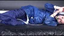 Lucy ties and gagges herself with cuffs on a bed wearing sexy blue shiny nylon rainwear (Video)