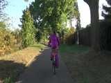 Watch Sandra riding her Bike in her sexy pink shiny nylon Rainsuit