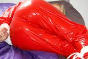 Samantha tied and gagged on bed wearing a shiny red PVC sauna suit (Pics)