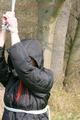 Jill tied, gagged and hooded on a tree outdoor wearing a shiny black down jacket (Pics)