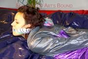 Lulu tied and gagged on a bed wearing a supersexy purple shiny nylon shorts, high heels and a purple rain jacket (Pics) 