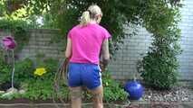 Watch Maly in her shiny nylon Shorts enjoying the warm Weather in the Garden