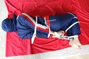 Julia tied and gagged in a shiny nylon skisuit