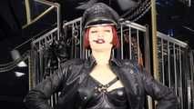 Mistress Tokyo smoking cigarette in leather, gloves and Muir Cap; fetish, POV