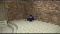 Jill tied and gagged on the floor in an old cellar wearing a shiny blue PVC sauna suit (Video)