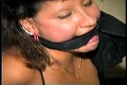 33 YEAR OLD AMERICAN INDIAN TRISH IS HANDCUFFED, MOUTH STUFFED, CLEAVE GAGGED, CHAIR TIED, BALL-GAGGED, HANDGAGGED WEARING LINGERIE, GARTER BELT, NYLONS & HEELS (D70-10)