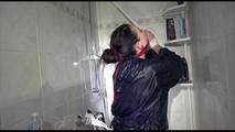 Jill tied and gagged taking a shower wearing sexy shiny nylon shorts and a rain jacket (Video)