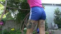 Watch Maly in her shiny nylon Shorts enjoying the warm Weather in the Garden