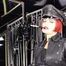 Mistress Tokyo smoking cigarette in leather, gloves and Muir Cap; fetish, POV