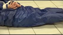 Jill tied and gagged on the floor in an old cellar wearing a shiny blue PVC sauna suit (Video)