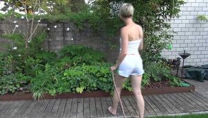 Sexy Sonja wearing a *white* shiny nylon shorts with a white top durig watering the garden (Video)