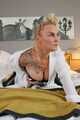Blonde Frida posiert in Ledercorsage und Glanz-Leggins auf dem Bett