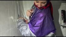 Mara wearing a sexy purple/silver pvc combination tied and gagged on a shower (Video)