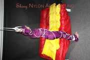 Watching sexy Sonja wearing a supersexy purple shiny nylon rainwear combination being tied and gagged overhead with ropes and a clothgag (Pics)