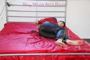 Jill tied and gagged on the bed with cable binders in a black shiny nylon pant and an red/Blue shiny rain jacket (Pics)