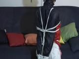 Katharina tied and gagged on a sofa wearing a shiny white nylon shorts and a shiny red/blue oldschool rain jacket (Video)