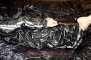 Pia tied and gagged on bed wearing a shiny black PVC sauna suit (Pics)