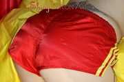 Watching Mara wearing ONLY a hot red shiny nylon shorts posing and lolling on a sofa (Pics)