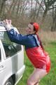 Jill tied and gagged outdoor on a car wearing a sexy red shiny nylon shorts and an oldschool rain jacket (Pics)