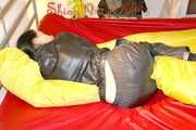 Lucy preparing her bed and enjoys it wearing sexy black rainwear (Pics)