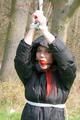 Jill tied, gagged and hooded on a tree outdoor wearing a shiny black down jacket (Pics)