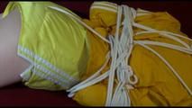Lucy tied and gagged on a red sofa wearing a supersexy yellow shiny nylon shorts and a yelow rain jacket (Video)
