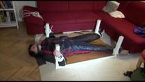 Mara tied and gagged on a bottom-up table wearing a supersexy black/red downwear combination (Video)
