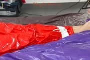 Samantha tied and gagged on bed wearing a shiny red PVC sauna suit (Pics)