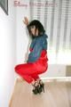 Stella wearing a red shiny nylon rain pants and an oldschool blue/red rain jacket while posing in the living room (Pics)