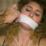 SUZIE IS GOZ & BLACK TAPE WRAPPED GAGGED & TIED WITH HER HANDS BEHIND HER HEAD & CROTCH ROPED (D33-14)