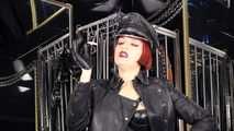 Mistress Tokyo smoking cigarette in leather, gloves and Muir Cap; fetish, POV