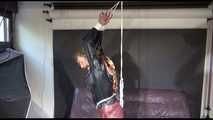 Sandra tied and gagged overhead with ropes wearing high heels, a sexy brown shiny nylon pant and a black rain jacket (Video)
