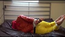 Pia tied and gagged on bed wearing a yellow rain pants and an orange downjacket (Video)