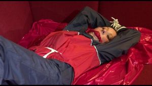 Lucy tied, gagged and hooded on a sofa wearing an oldschool rainwear combination (Video)
