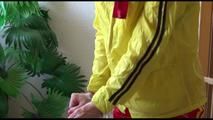 Pia tied and gagged on a stairway with cuffs wearing a sexy red/yellow shiny nylon shorts and a yellow rain jacket (Video)