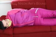 Jill tied and gagged on a red sofa wearing a sexy pink down combination (Pics)