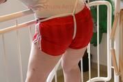 Jill tied and gagged standing on a stairway wearing a sexy red adidas shiny nylon shorts and a top (Pics)