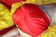 Watching Mara wearing ONLY a hot red shiny nylon shorts posing and lolling on a sofa (Pics)
