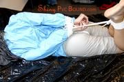 Pia tied and gagged on bed wearing a shiny lightblue/offwhite PVC combination (Pics)