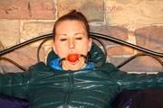 Mara tied and gagged on a princess bed in an old cellar wearing an supersexy shiny green down jacket and a rain pants (Pics)