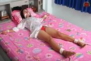 Asian Girl is Tied Spread on the Bed