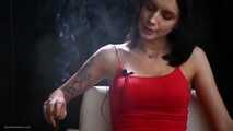 Sexy lady in red is smoking two 100mm reds