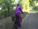 Watch Sandra riding her Bike in her sexy pink shiny nylon Rainsuit