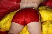 Watching Mara wearing ONLY a hot red shiny nylon shorts posing and lolling on a sofa (Pics)